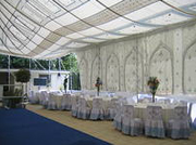 A marquee with tables and blue carpet set up in Sandhurst for a Wedding event